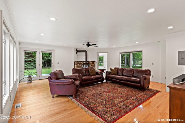 1701 Woo Blvd, Anchorage, AK 99515 - living area with plenty of natural light, recessed lighting, light wood-style flooring, and a wood stove
