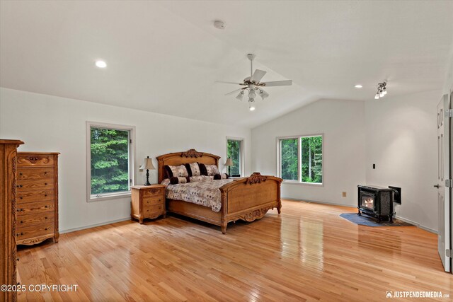 1701 Woo Blvd, Anchorage, AK 99515 - bedroom featuring a wood stove, multiple windows, lofted ceiling, light wood finished floors, and baseboards