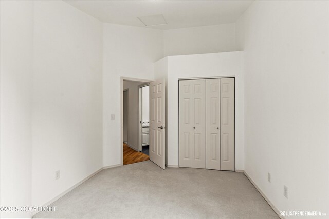 1701 Woo Blvd, Anchorage, AK 99515 - unfurnished bedroom with light carpet, baseboards, a closet, attic access, and a high ceiling