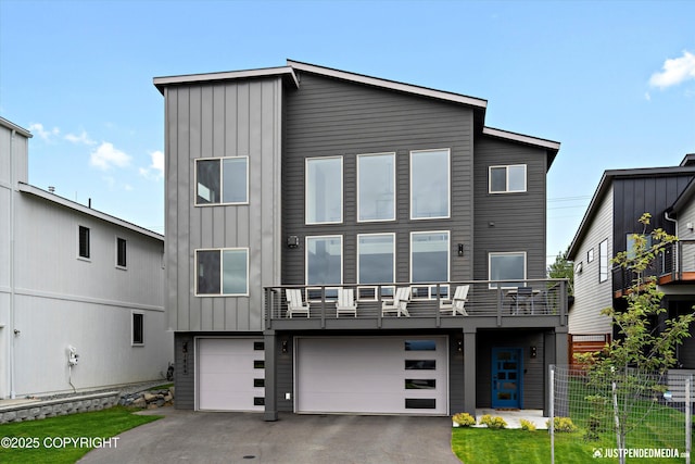 7864 Crane Cir, Anchorage, AK 99502 - rear view of property with board and batten siding, driveway, a balcony, and an attached garage