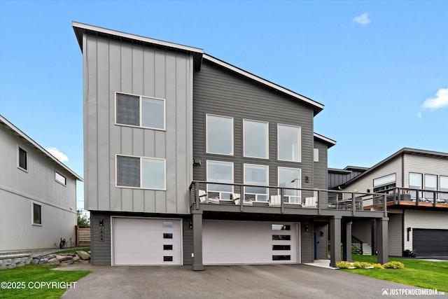 7864 Crane Cir, Anchorage, AK 99502 - modern home featuring board and batten siding, an attached garage, and asphalt driveway