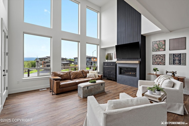 7864 Crane Cir, Anchorage, AK 99502 - living area featuring a fireplace, light wood finished floors, and a towering ceiling