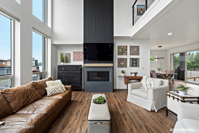 7864 Crane Cir, Anchorage, AK 99502 - living room featuring a towering ceiling, dark wood-type flooring, and a fireplace