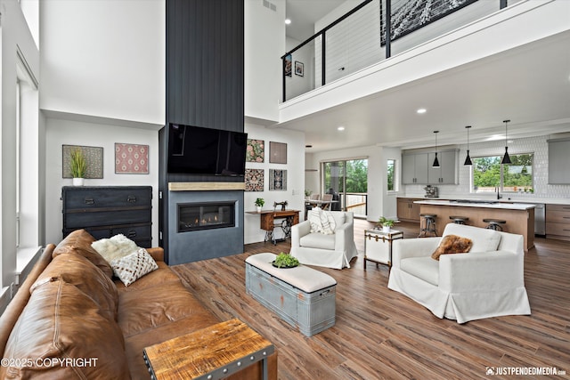 7864 Crane Cir, Anchorage, AK 99502 - living area with a high ceiling, a large fireplace, dark wood finished floors, and recessed lighting