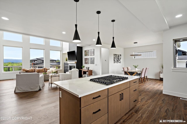 7864 Crane Cir, Anchorage, AK 99502 - kitchen with stainless steel gas cooktop, a kitchen island, dark wood finished floors, hanging light fixtures, and recessed lighting