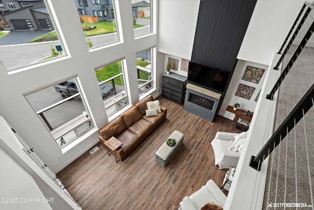 7864 Crane Cir, Anchorage, AK 99502 - living room with wood finished floors, a high ceiling, and a large fireplace
