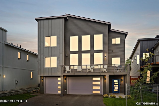 7864 Crane Cir, Anchorage, AK 99502 - view of front of home featuring board and batten siding, a balcony, a garage, and asphalt driveway