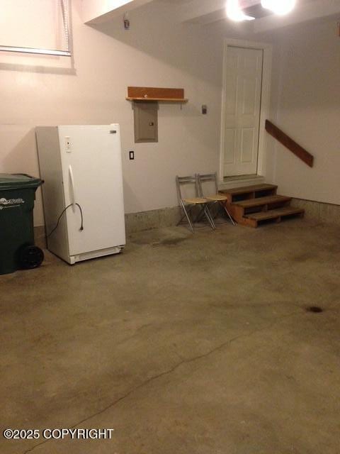17491 Fire Eagle Way # 6, Eagle River, AK 99577 - garage with freestanding refrigerator, electric panel, and a ceiling fan