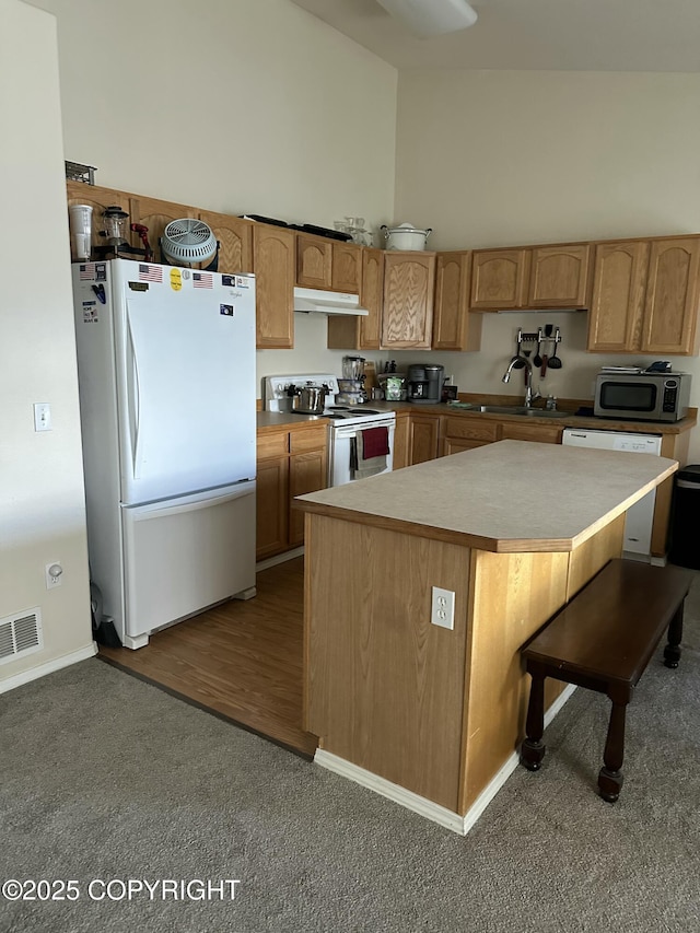 17491 Fire Eagle Way # 6, Eagle River, AK 99577 - kitchen featuring white appliances, a sink, under cabinet range hood, carpet floors, and a high ceiling