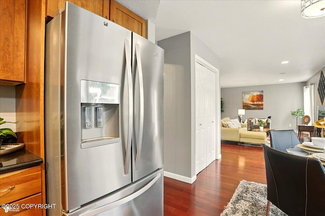2350 Ariel Cir, Anchorage, AK 99515 - kitchen with stainless steel fridge with ice dispenser, dark wood-style floors, brown cabinets, open floor plan, and baseboards
