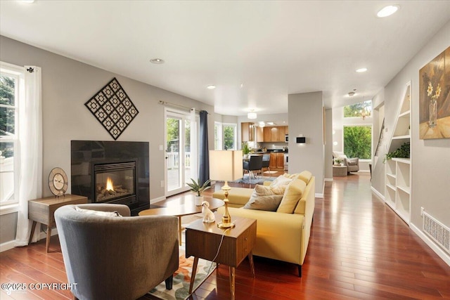 2350 Ariel Cir, Anchorage, AK 99515 - living area with wood finished floors, a glass covered fireplace, recessed lighting, baseboards, and built in features