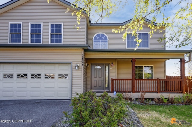5893 Kenai Fjords Loop, Anchorage, AK 99502 - traditional home featuring a porch, a garage, and asphalt driveway