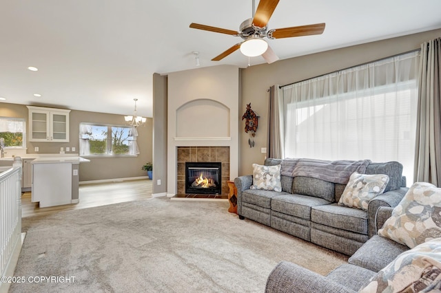 5893 Kenai Fjords Loop, Anchorage, AK 99502 - living room with healthy amount of natural light, a ceiling fan, a chandelier, and a tile fireplace