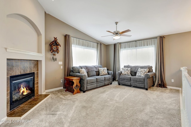 5893 Kenai Fjords Loop, Anchorage, AK 99502 - living room with vaulted ceiling, a tiled fireplace, a ceiling fan, carpet floors, and baseboards