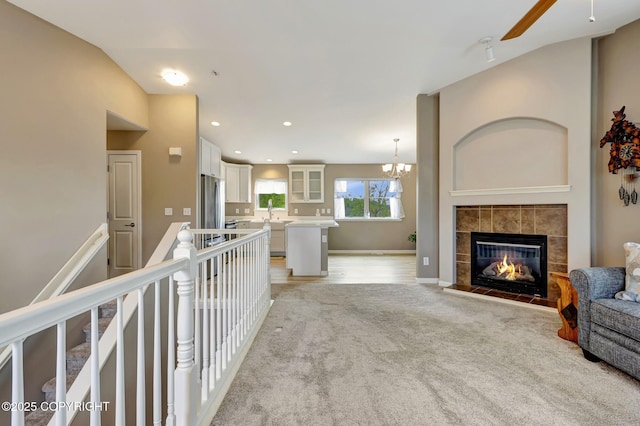 5893 Kenai Fjords Loop, Anchorage, AK 99502 - living room with light carpet, a tile fireplace, recessed lighting, ceiling fan, and a chandelier