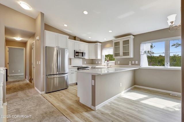 5893 Kenai Fjords Loop, Anchorage, AK 99502 - kitchen with appliances with stainless steel finishes, a sink, a peninsula, glass insert cabinets, and white cabinets