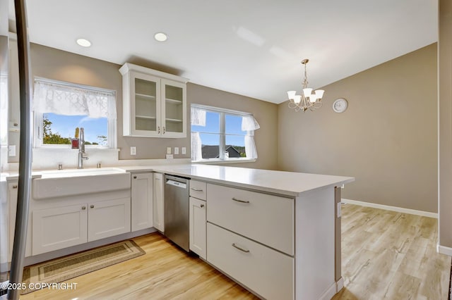 5893 Kenai Fjords Loop, Anchorage, AK 99502 - kitchen featuring dishwasher, a peninsula, light countertops, a chandelier, and light wood finished floors