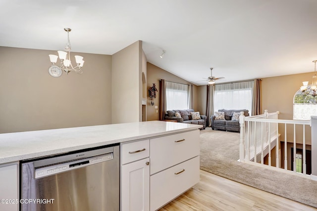 5893 Kenai Fjords Loop, Anchorage, AK 99502 - kitchen with stainless steel dishwasher, a chandelier, white cabinetry, light countertops, and vaulted ceiling