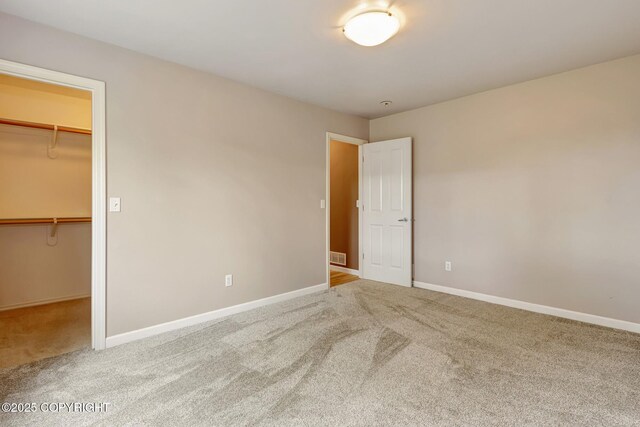 5893 Kenai Fjords Loop, Anchorage, AK 99502 - unfurnished bedroom with carpet floors, a walk in closet, baseboards, and a closet