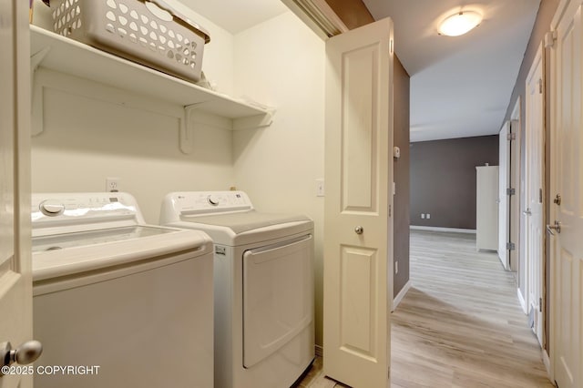 5893 Kenai Fjords Loop, Anchorage, AK 99502 - washroom with washing machine and clothes dryer, light wood-style floors, and baseboards