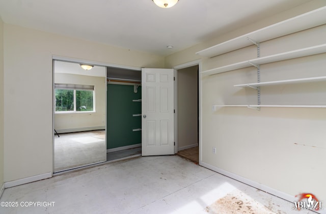 4106 E Country Fair Dr # A, Wasilla, AK 99654 - unfurnished bedroom with baseboards, concrete floors, a baseboard radiator, and a closet