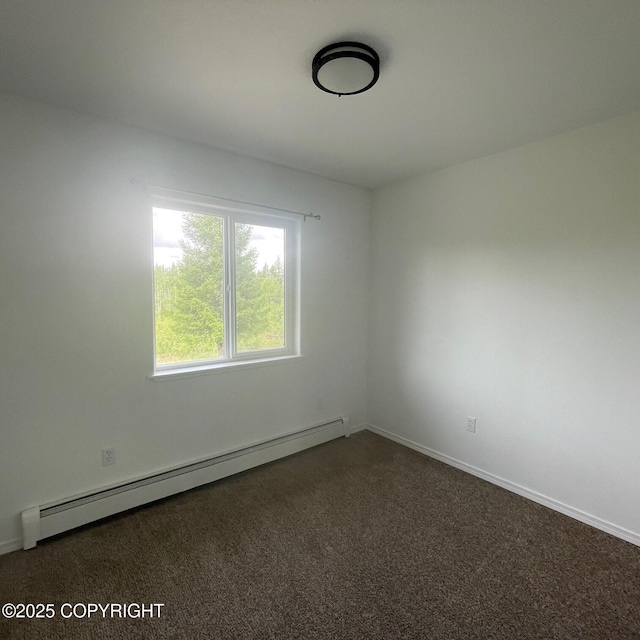 14154 Jojoba Dr, Wasilla, AK 99654 - empty room featuring a baseboard heating unit, dark carpet, and baseboards