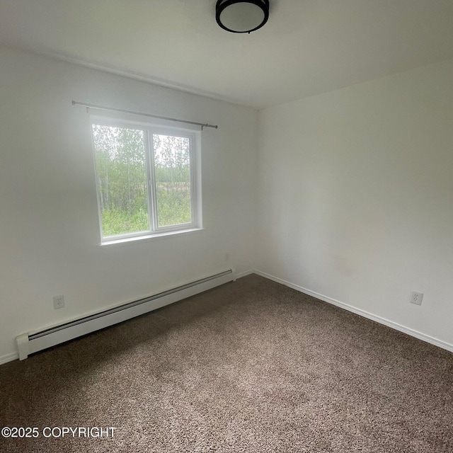 14154 Jojoba Dr, Wasilla, AK 99654 - spare room featuring a baseboard heating unit, dark carpet, and baseboards