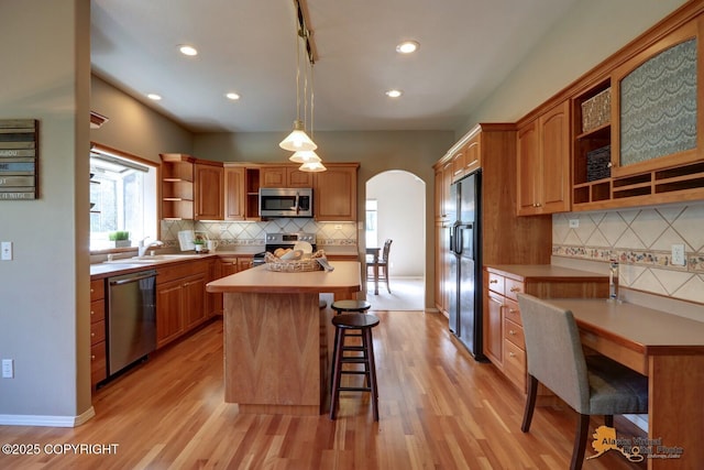 16059 Hidden Creek Ln, Anchorage, AK 99516 - kitchen featuring open shelves, appliances with stainless steel finishes, a breakfast bar, decorative backsplash, and a kitchen island