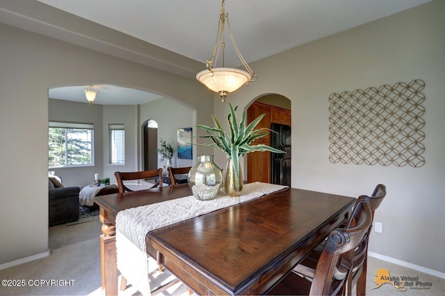 16059 Hidden Creek Ln, Anchorage, AK 99516 - dining area with arched walkways, light colored carpet, and baseboards