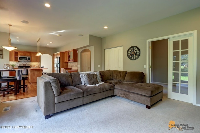 16059 Hidden Creek Ln, Anchorage, AK 99516 - living room with arched walkways, light carpet, and recessed lighting