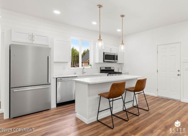 1338 N Unicorn Cir, Palmer, AK 99645 - kitchen featuring stainless steel appliances, a breakfast bar, a sink, a kitchen island, and white cabinetry