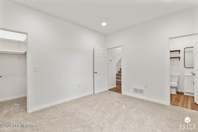 1338 N Unicorn Cir, Palmer, AK 99645 - unfurnished bedroom featuring carpet flooring, a walk in closet, a closet, baseboards, and recessed lighting