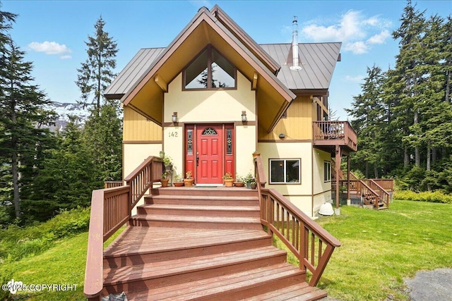 142 Vail Cir, Girdwood, AK 99587 - view of front of house featuring a front lawn, a standing seam roof, metal roof, and a balcony