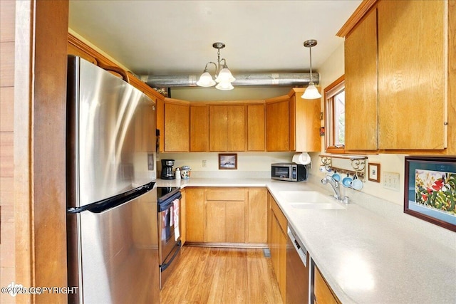 142 Vail Cir, Girdwood, AK 99587 - kitchen featuring appliances with stainless steel finishes, a sink, light countertops, light wood finished floors, and a chandelier