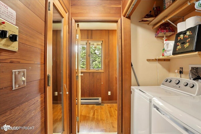 142 Vail Cir, Girdwood, AK 99587 - laundry area featuring separate washer and dryer, a baseboard radiator, wood finished floors, and wooden walls