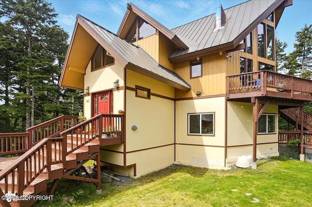 142 Vail Cir, Girdwood, AK 99587 - back of property with a standing seam roof, stairway, a lawn, a deck, and metal roof