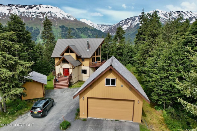 142 Vail Cir, Girdwood, AK 99587 - view of front of home with a mountain view, an outbuilding, a balcony, and metal roof