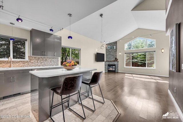 268 Dailey Ave, Anchorage, AK 99515 - kitchen with a sink, gray cabinetry, a fireplace, light countertops, and a kitchen bar