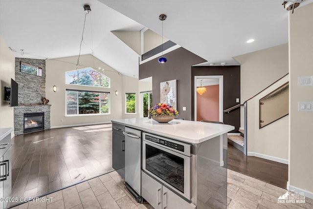 268 Dailey Ave, Anchorage, AK 99515 - kitchen with a kitchen island, light wood-type flooring, light countertops, open floor plan, and a stone fireplace