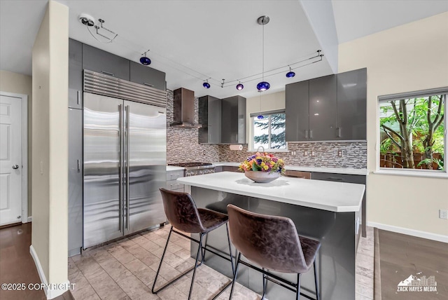 268 Dailey Ave, Anchorage, AK 99515 - kitchen featuring stainless steel built in refrigerator, wall chimney range hood, decorative backsplash, and track lighting