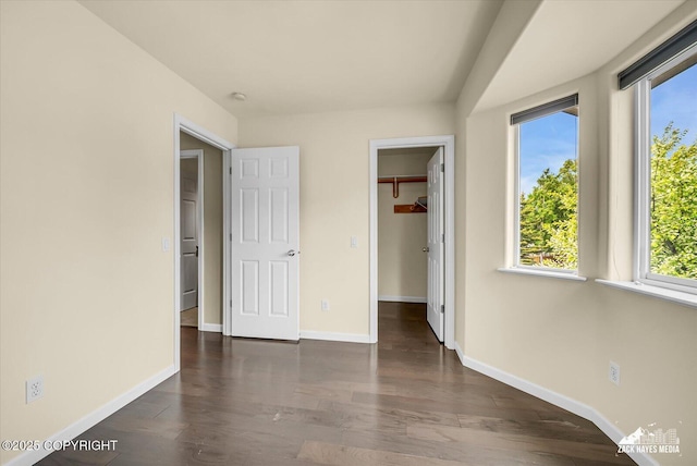 268 Dailey Ave, Anchorage, AK 99515 - unfurnished bedroom with multiple windows, a spacious closet, baseboards, and wood finished floors