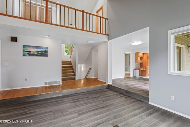 11751 Mary Ave, Anchorage, AK 99515 - unfurnished living room with wood finished floors, a towering ceiling, and stairway