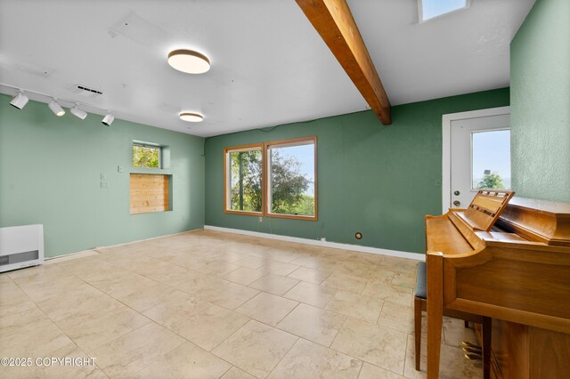 1855 Mission Rd, Homer, AK 99603 - empty room featuring rail lighting, heating unit, and beam ceiling