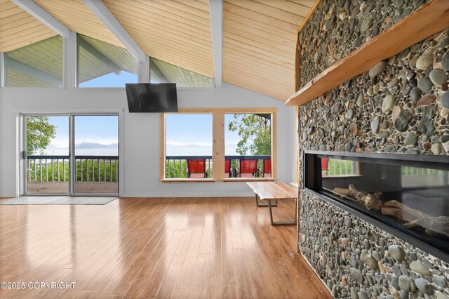 1855 Mission Rd, Homer, AK 99603 - unfurnished living room with hardwood / wood-style flooring, high vaulted ceiling, a fireplace, and a wooden ceiling with exposed beams