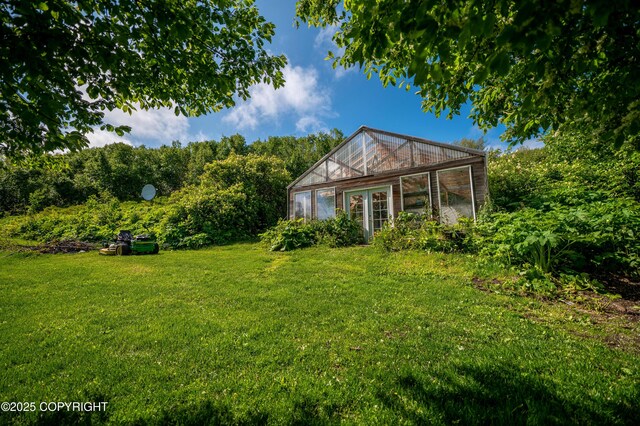1855 Mission Rd, Homer, AK 99603 - view of green lawn featuring a greenhouse and an outbuilding