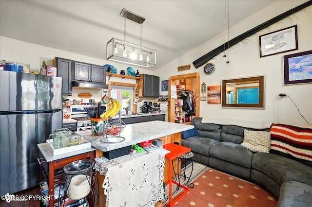9637 N Buckingham Palace Rd, Willow, AK 99688 - kitchen featuring freestanding refrigerator, light countertops, open floor plan, under cabinet range hood, and decorative light fixtures