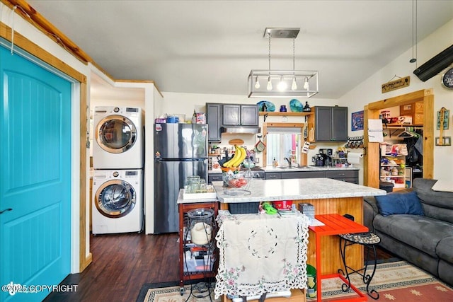 9637 N Buckingham Palace Rd, Willow, AK 99688 - kitchen with stacked washer / drying machine, freestanding refrigerator, light countertops, a sink, and dark wood-type flooring