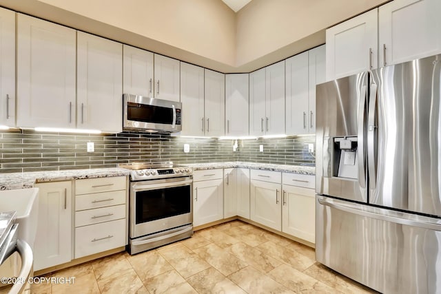 333 M St # 402, Anchorage, AK 99501 - kitchen featuring appliances with stainless steel finishes, tasteful backsplash, and white cabinetry