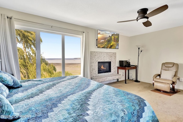 333 M St # 402, Anchorage, AK 99501 - bedroom with carpet floors, a lit fireplace, ceiling fan, and baseboards
