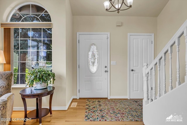 10201 Sextant Cir, Anchorage, AK 99515 - entrance foyer with light wood finished floors, baseboards, a chandelier, and stairs
